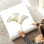 affiche avec illustration de deux feuilles de ginkgo dorees avec un design graph au sol.webp