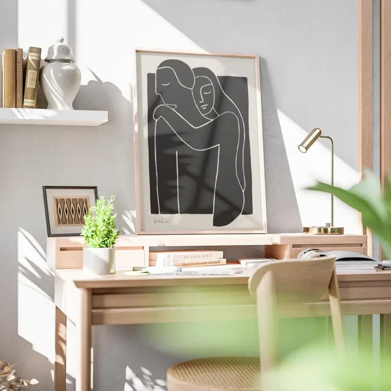 affiche avec illustration de deux personnes enlacees en typographie blanche sur bureau.webp
