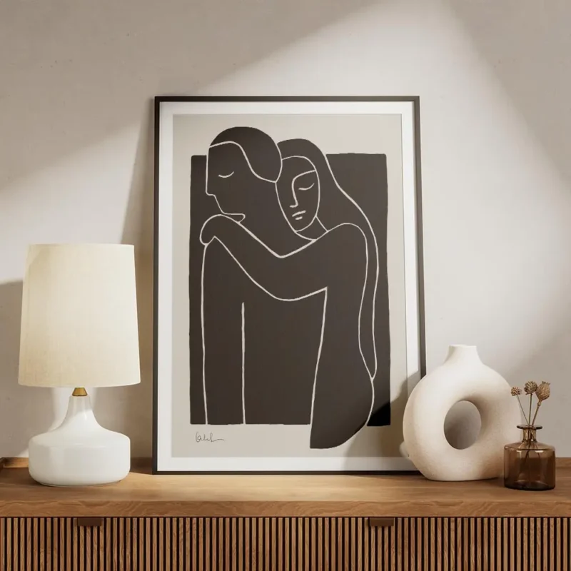 affiche avec illustration de deux personnes enlacees en typographie blanche sur meuble.webp