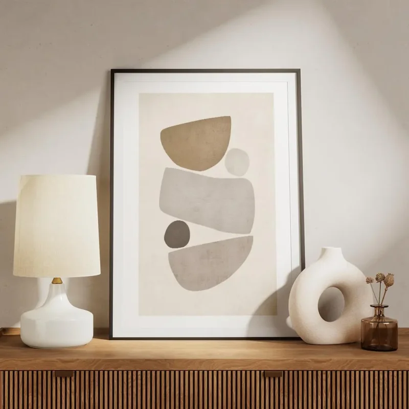 affiche avec illustration de formes abstraites et texturees en beige et gris sur meuble.webp