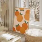affiche avec illustration de plusieurs oranges et feuilles vertes sur fond clair salon beige.webp