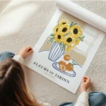 affiche avec illustration de tournesols dans un vase raye et doranges sur une as en rouleau.webp
