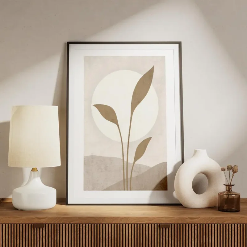 affiche avec illustration dun soleil blanc derriere des feuilles beiges sur un f meuble.webp