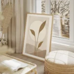 affiche avec illustration dun soleil blanc derriere des feuilles beiges sur un f salon beige.webp