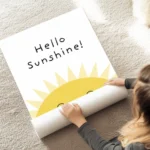 affiche avec illustration dun soleil jaune souriant et le texte hello sunshine e au sol.webp