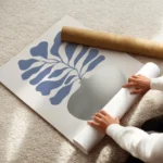 affiche avec illustration dun vase argente aux feuilles bleues sur fond clair enroule.webp