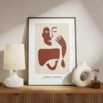 affiche avec illustration graphique rouge et beige dun visage abstrait et dune m meuble.webp