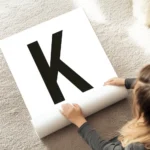 affiche avec la lettre k noire en typographie sur fond blanc texte personnalisab au sol.webp