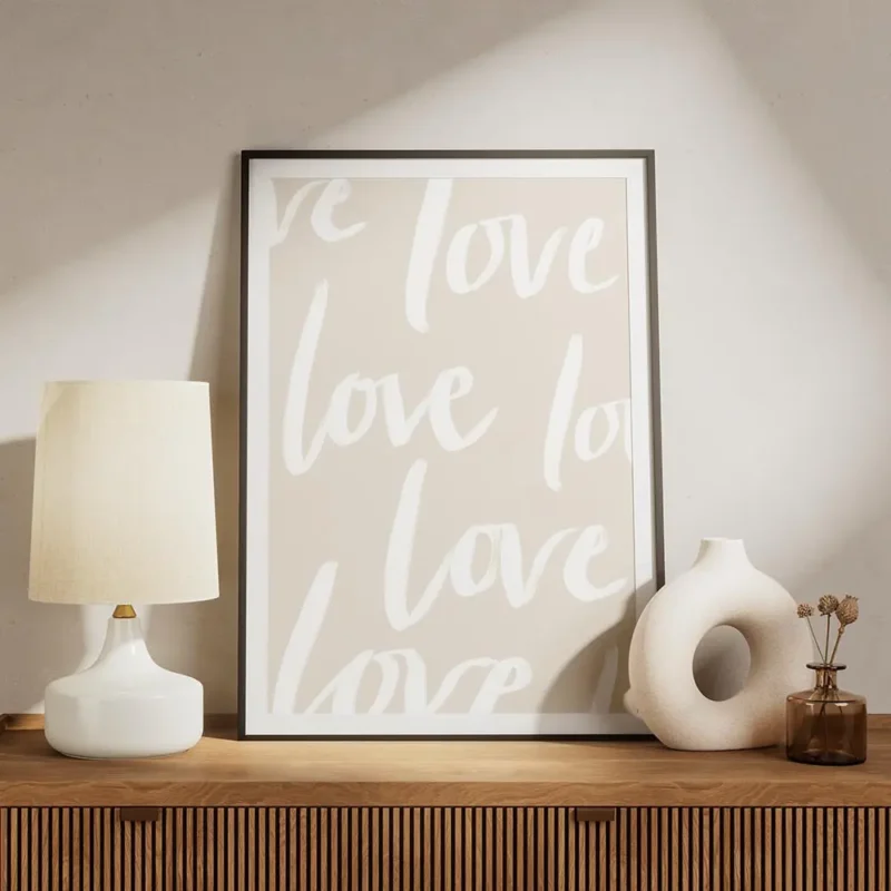 affiche avec le mot love en typographie blanche repetee sur un fond beige clair meuble.webp