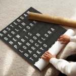 affiche avec le texte des noms de villes en typographie blanche sur fond noir co enroule.webp