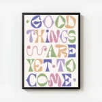affiche avec le texte good things are yet to come en typographie coloree nuances avec cadre.webp