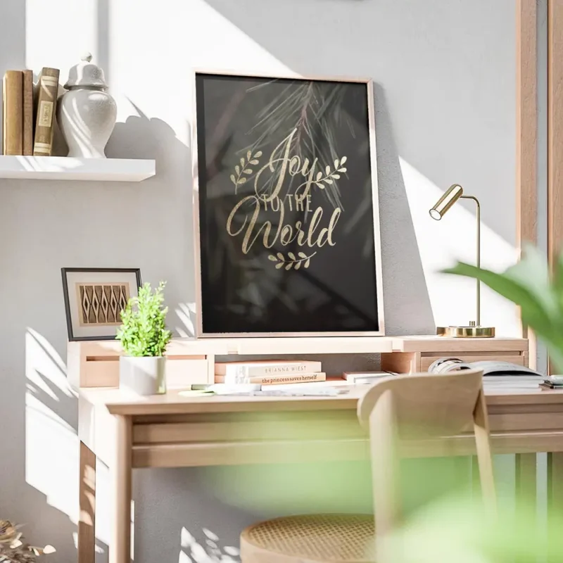 affiche avec le texte joy to the world en typographie doree sur un fond vert fon bureau.webp