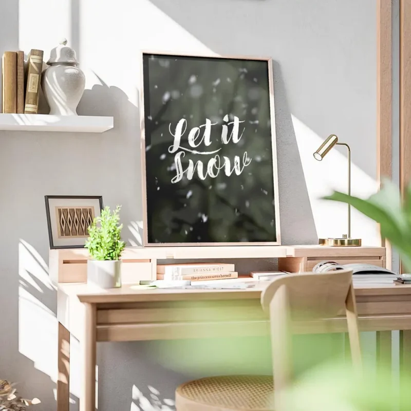 affiche avec le texte let it snow en typographie blanche manuscrite sur un fond bureau.webp