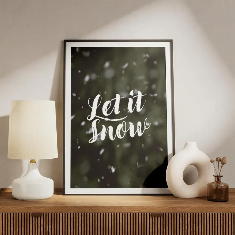 affiche avec le texte let it snow en typographie blanche manuscrite sur un fond meuble.webp