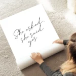 affiche avec le texte she asked she said yes en typographie manuscrite noire sur au sol.webp