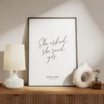 affiche avec le texte she asked she said yes en typographie manuscrite noire sur meuble.webp