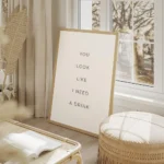 affiche avec le texte you look like i need a drink en typographie noire fine sur salon beige.webp
