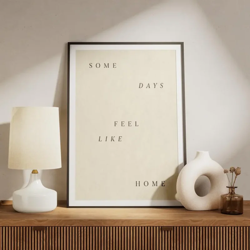affiche avec les mots some days feel like home en lettres marron sur fond beige meuble.webp