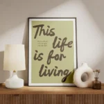 affiche avec les mots this life is for living en marron sur fond vert pale et un meuble.webp