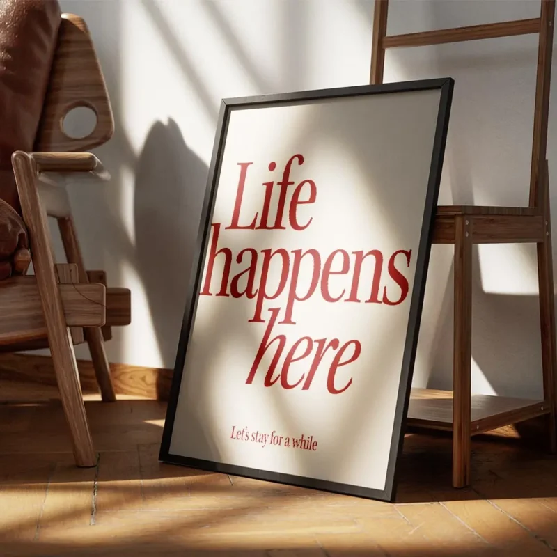 affiche avec linscription life happens here en rouge fonce et lets stay for a wh encadre.webp
