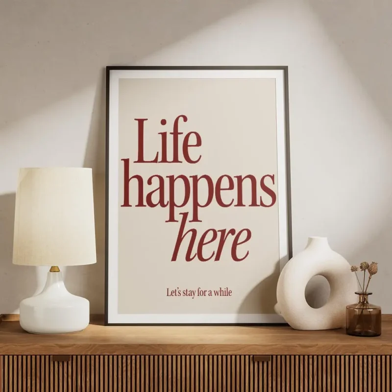 affiche avec linscription life happens here en rouge fonce et lets stay for a wh meuble.webp