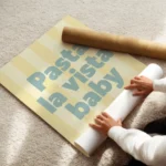 affiche avec linscription pasta la vista baby en bleu sur fond raye jaune clair enroule.webp