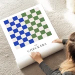 affiche avec motif de damier vert et bleu typographie the check era au sol.webp
