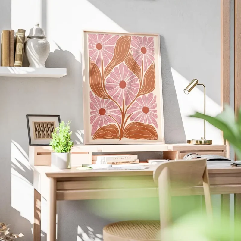 affiche avec motif floral stylise cinq fleurs roses et feuilles orange sur fond bureau.webp