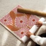 affiche avec motif floral stylise cinq fleurs roses et feuilles orange sur fond enroule.webp