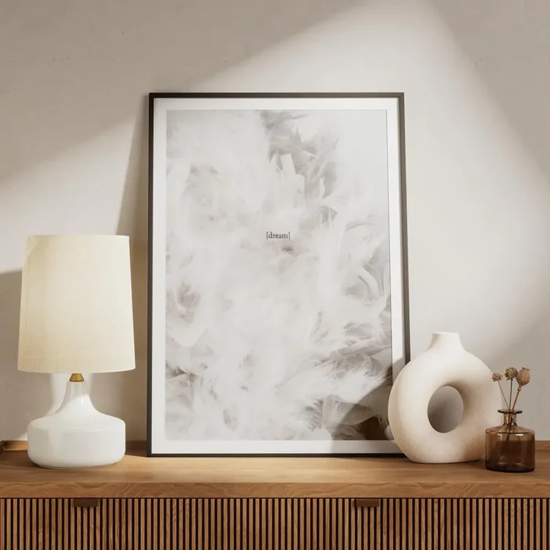 affiche avec photographie de plumes blanches et le texte dream en typographie au meuble.webp
