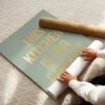 affiche avec texte dore this kitchen is for dancing sur fond vert clair typograp enroule.webp