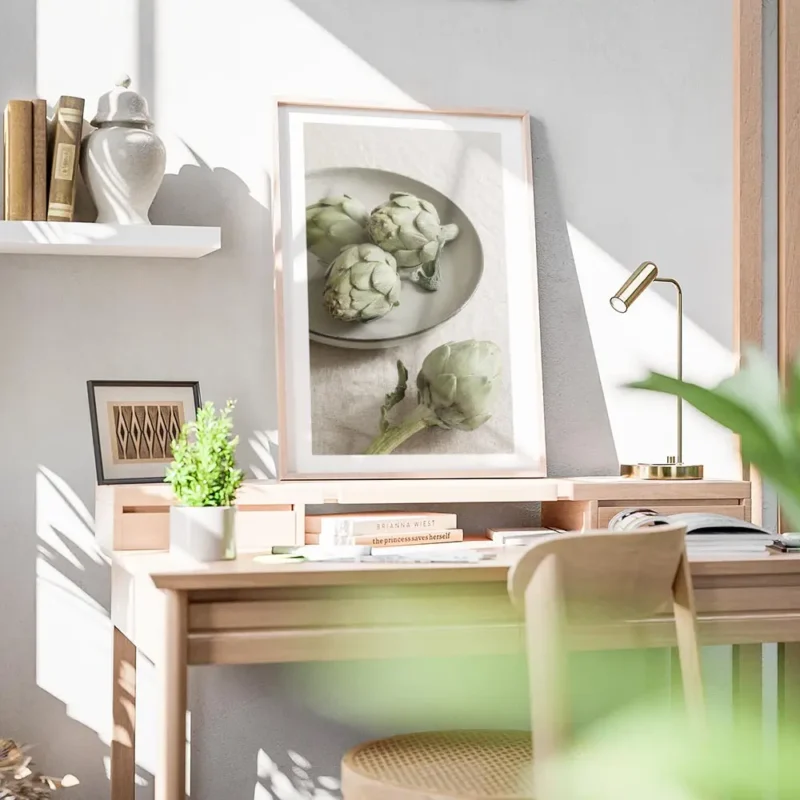 affiche avec trois artichauts vert sur une assiette grise et un artichaut seul s bureau.webp
