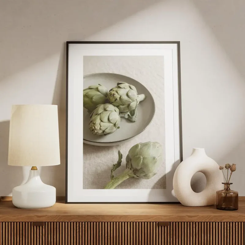 affiche avec trois artichauts vert sur une assiette grise et un artichaut seul s meuble.webp