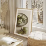 affiche avec trois artichauts vert sur une assiette grise et un artichaut seul s salon beige.webp
