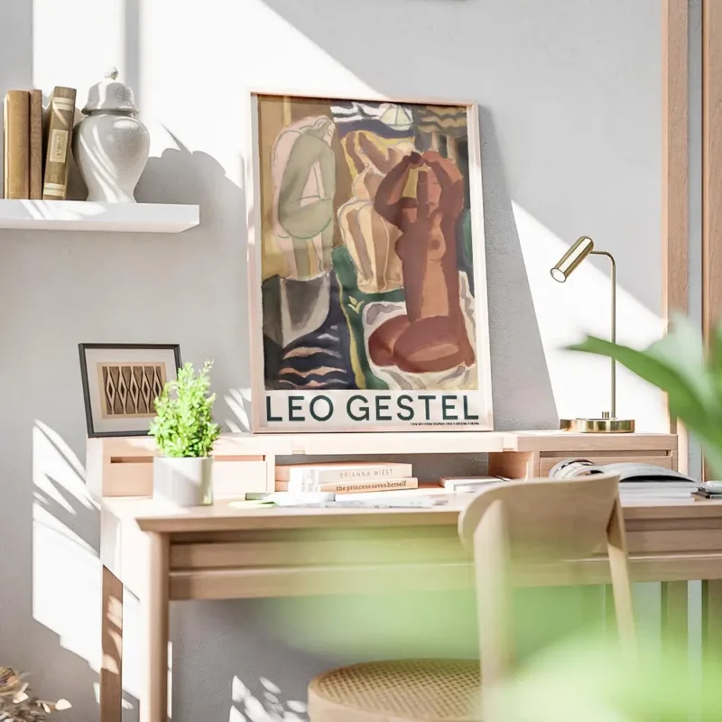affiche avec trois figures feminines nues dans des tons ocres bruns et verts sur bureau.webp