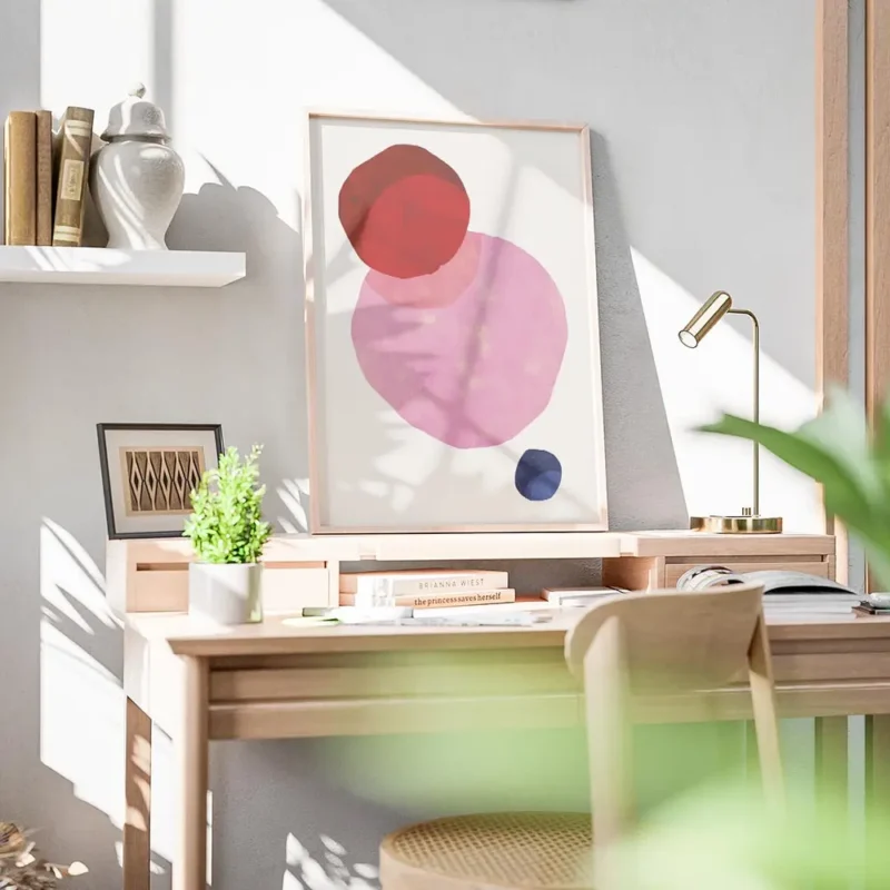 affiche avec trois formes rondes aux teintes vives rouge rose et bleu fonce sur bureau.webp