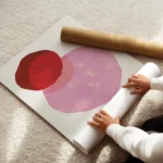 affiche avec trois formes rondes aux teintes vives rouge rose et bleu fonce sur enroule.webp