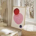affiche avec trois formes rondes aux teintes vives rouge rose et bleu fonce sur salon beige.webp