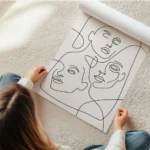 affiche avec trois visages feminins esquisses en lignes noires continues sur un en rouleau.webp
