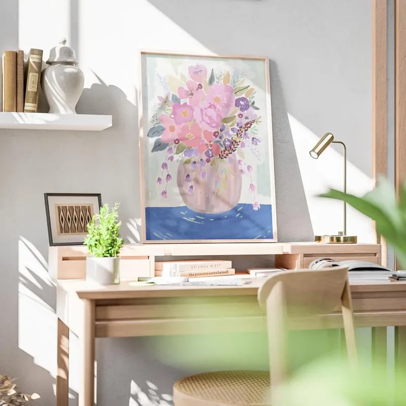 affiche avec un bouquet de fleurs colorees roses et violettes dans un vase sur u bureau.webp