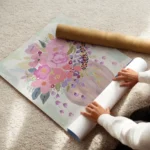 affiche avec un bouquet de fleurs colorees roses et violettes dans un vase sur u enroule.webp