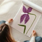 affiche avec un dessin de lys violet avec des taches marron et une tige verte su en rouleau.webp