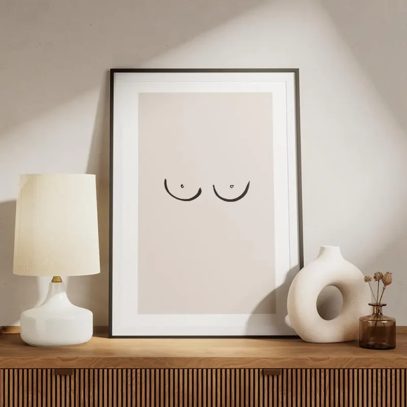 affiche avec un dessin minimaliste de seins sur fond rose pale typographie noire meuble.webp