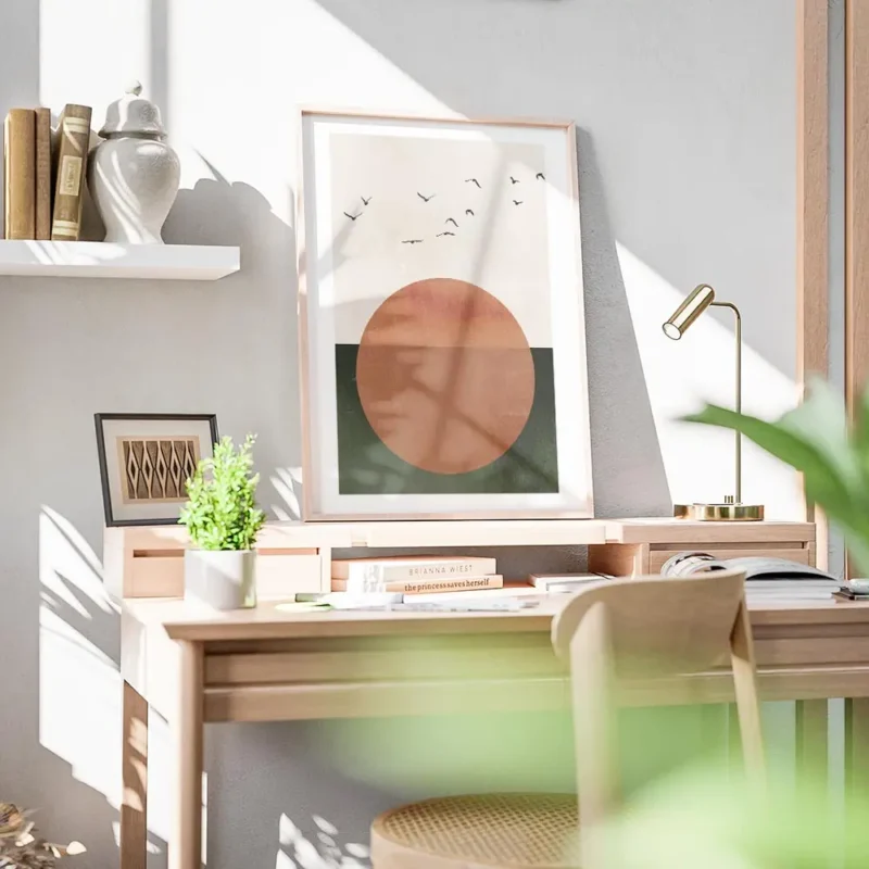 affiche avec un grand soleil orange sur fond beige et vert survole par des oisea bureau.webp