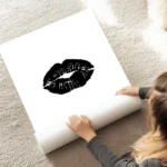 affiche avec un motif de levres noires sur fond blanc style typographie au sol.webp