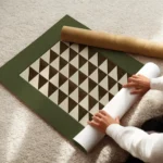 affiche avec un motif geometrique de triangles beiges et marron sur fond vert enroule.webp