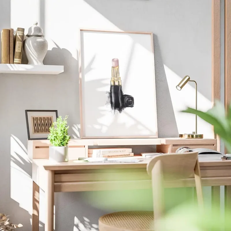 affiche avec un rouge a levres chanel rose pale et dore sur fond blanc avec une bureau.webp