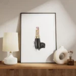 affiche avec un rouge a levres chanel rose pale et dore sur fond blanc avec une meuble.webp