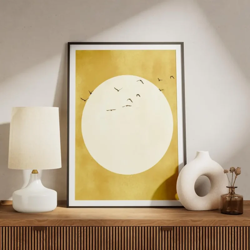 affiche avec un soleil jaune pale et des oiseaux noirs volant autour sur fond te meuble.webp