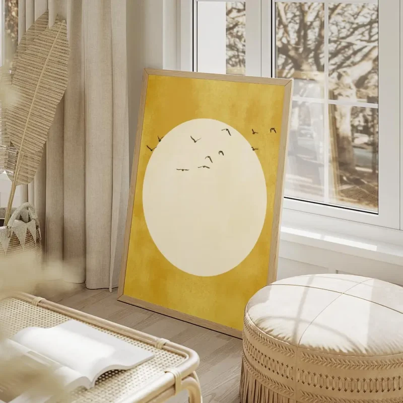 affiche avec un soleil jaune pale et des oiseaux noirs volant autour sur fond te salon beige.webp